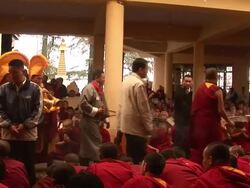 MS His Holiness Dalai Lama walks by crowd with monks wearing ceremonial attire and playing horns lead way AUDIO / Dharamsala, Himachal Pradesh, India Stock Footage