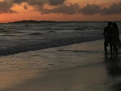 Good Looking Young Couple walking by the Sea at Sunset Stock Footage