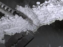 CU SLO MO Syringe falling on drug powder against black background / Vieux Pont, Normandy, France Stock Footage