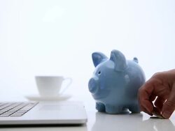 Coins being placed in blue piggy bank, one by one. Stock Footage