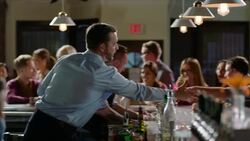Bartenders work as manager greets and shakes hands with customers in crowded bar Stock Footage