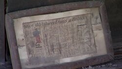 A newspaper article in a wooden frame bears water damage in the aftermath of a flood. Stock Footage