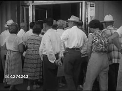1952: LAS VEGAS, NEVADA: BANKING: TU Vertical sign 'First National Bank of Nevada', crowd of people moving into bank, VS Crowded bank lobby w/ people standing in teller lines, filling out slips at counter island.    Depositing, withdrawing, in person. Instructional Video