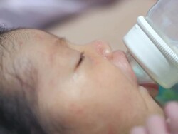 Baby infant suckling milk from bottle Stock Footage