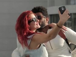 Young biracial couple taking selfie with mobile device, smiling, kissing with sunglasses Stock Footage