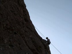 Climber descending cliff using rope Stock Footage