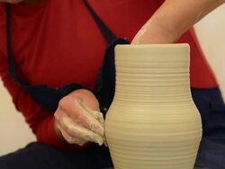 CU Shot of female potter shapes pitcher on potterwheel at pottery / Landshut, Bavaria, Germany Stock Footage