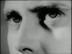 A man wearing headphones moves his eyes while he listens. News Clip