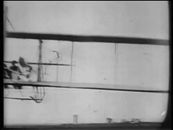 B/W 1900s REAR VIEW Wright brothers in biplane flying away from camera / documentary Stock Footage