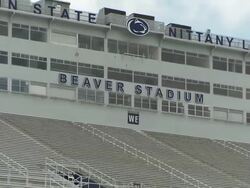Shot of the Beaver Stadium sign at Pennsylvania State University. Shot pulls out revealing the rest of the Beaver Stadium's press box Stock Footage