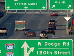 Ambulance revealed from behind overhead highway signs Stock Footage
