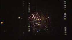 Fireworks sizzle and sparkle over a rooftop in Beijing. Stock Footage