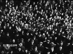 1936: GERMANY: HA TD XWS HUGE Crowd of people in open square, crowd 'flows' forward. TD Crowd of people, one waving Nazi flag. WS German Nazi Officers looking upward, saluting, waving. TU Adolf Hitler on balcony, small salute. HA TD XWS HUGE Crowd Instructional Video
