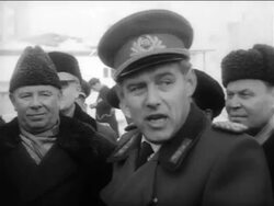 B/W 1961 close up East German guard talking to Soviets + pointing outdoors / East Berlin / Cold War Stock Footage