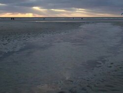 EWS View of people walking and playing with beach kites in sea ebb tide during sunset , North Sea North Frisia, / St. Peter Ording, Schleswig Holstein, Germany Stock Footage