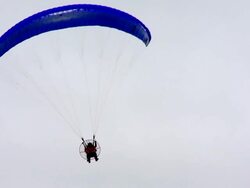 A paramotor flying in a cloudy sky Stock Footage