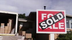 Close up of Sold sign in front of house with moving truck Stock Footage