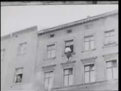 B/W 1961 low angle person on window ledge of building on border of East + West Berlin / Germany / newsreel Stock Footage