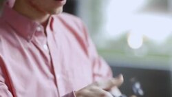 Young man checks price tag, holds up shirt for a better look, and hangs it back on the rack in clothing store Stock Footage