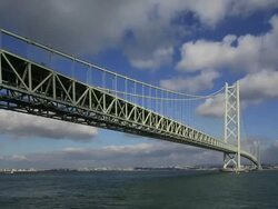 WS T/L View of Traffivc moving on Akashi Kaikyo Bridge, longest central span of any suspension bridge in world / Awaji, Awaji Island, Japan Stock Footage
