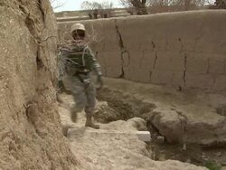 MS Soldier and national police walking from dirt track / Musa Qala, Helmand Province, Afghanistan. Stock Footage