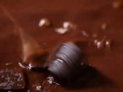 Ice cube dipping into a liquid chocolate  Stock Footage