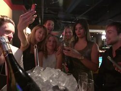 friends laughing and taking pics in nighclub lounge Stock Footage