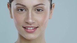 Close-up of young woman with glowing skin taking a vitamin pill and smiling Stock Footage