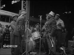 1952: NEW ORLEANS PORT: WS Dixieland Jazz band playing outside on dock, MS Del Sud freighter, VS People walking up Delta Steamship Line cruise ship ramp, VS People on ship, on dock waiting.  Ocean liner, Iconic. Instructional Video