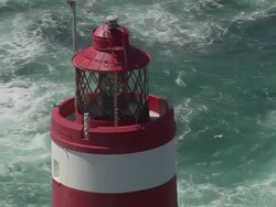 CU AERIAL DS ZO Shot of Casquets Lighthouse and sea waves crashing on rock stones / Alderney, Channel Isles Stock Footage