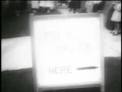 B/W 1955 close up "Polio Shots Here" sign outdoors / newsreel Stock Footage