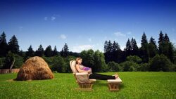 A pregnant woman relaxes in a glider against a computer generated farm field. Stock Footage