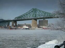 Smoke and ice floating on the water with Jacques-Cartier bridge in Montreal Stock Footage