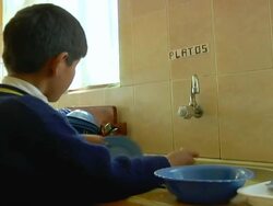 MS ZO PAN Shot of little boy washing dishes at school / Potosi, Bolivia Stock Footage
