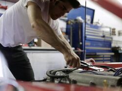 MS Young mechanic working on car inside  garage / Bayport, Minnesota, United States Stock Footage