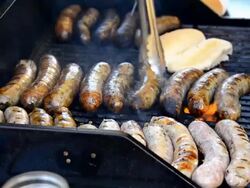 Cook grilling sausages during Dundas West Festival Stock Footage