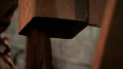 A gritty substance pours out of a chute. Stock Footage
