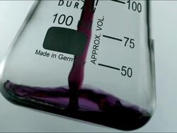 High speed CU purple chemical liquid pouring into glass Stock Footage