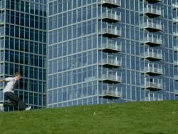 WS SLO MO Three men run across frame doing flips in city center / Denver, Colorado, United States Stock Footage