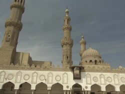 Wide Shot, pan-right tilt-down - An onion dome and minarets overlook the courtyard of a beautiful mosque / Egypt Stock Footage