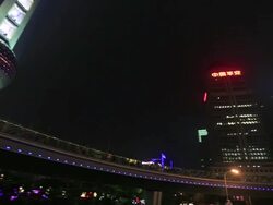 Streetscape of Pudong and Oriental Pearl Tower from a running car at night Stock Footage