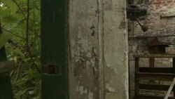 A broken fence leads to an abandoned factory building. Stock Footage