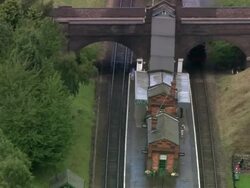 Aerial steam locomotive pulling into station on Great Central Railway / Leicestershire, England Stock Footage