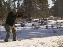 MS SLO MO Shot of man shoots an AK-47 rifle in slow motion in winter wood landscape / Bend, Oregon, United States  Stock Footage