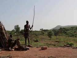 Pan of mother and son in front of hut Stock Footage