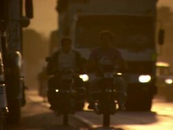 "Busy major road with large trucks and motorbikes in orange dusky light, Trujillo, Peru" Stock Footage