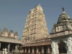 MS Visitors walking in front of Virupaksha Temple, which is dedicated to the goddess Pampa and her consort Shiva/ Hampi, Karnataka, India Stock Footage