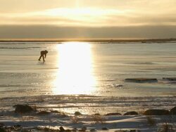WS Shot of hockey player skating on ice with sun reflection / Arviat, Nunavut, Canada Stock Footage