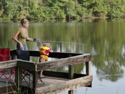  WS PAN Mother and daughter fishing on dock / St. Simon's Island, Georgia, USA Stock Footage