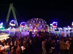 MS Shot of People enjoying amusement ride at funfair, flying bobs with people walking / Cologne, Germany Stock Footage